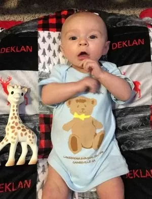 A newborn baby with a toy giraffe