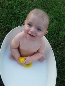 A baby sitting in a tub