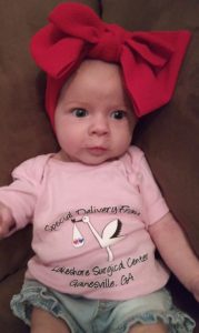A baby wearing a red bow