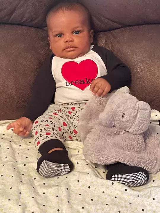 A baby with an elephant stuffed animal